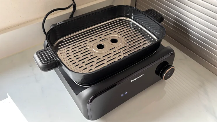 The Panasonic 6-in-1 Table-top Multi Cooker on a kitchen surface. The deep pot is attached, with steam plate