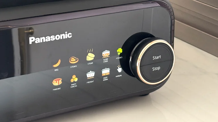 A closeup of the Panasonic 6-in-1 Table-top Multi Cooker's digital display, showing the different cooking modes