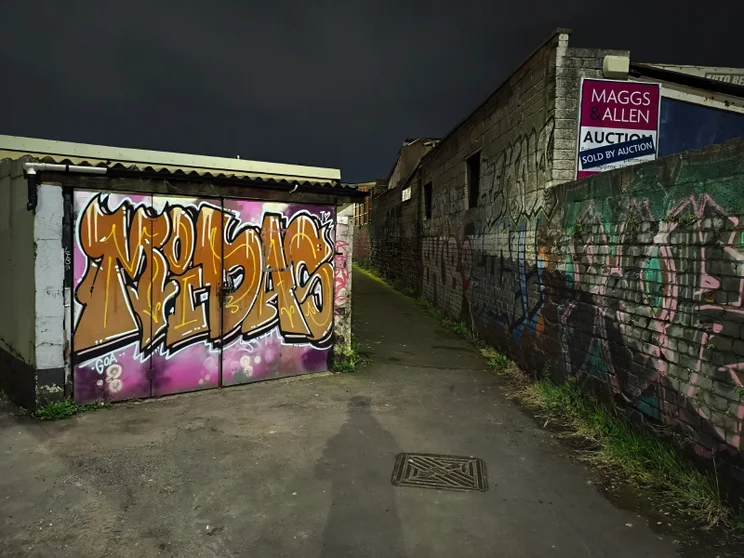 A dark alleyway with graffiti-covered walls