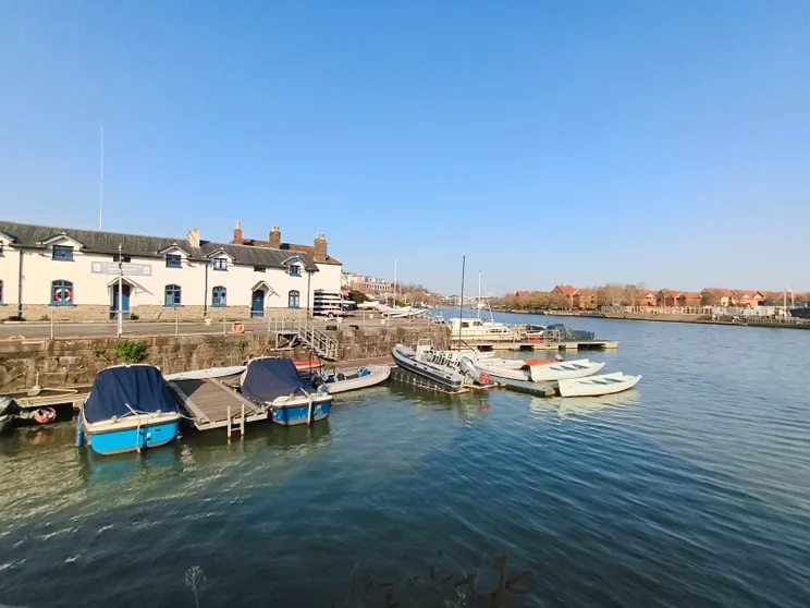 Wide-angle shot of a river with boats moored at a jetty