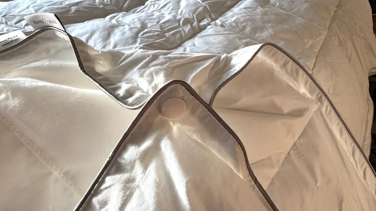 A closeup of the Soak & Sleep Soft as Down duvet's corner, showing its fastener