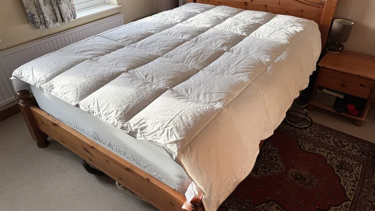 The Soak & Sleep Soft as Down duvet on a bed