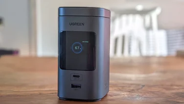 The Ugreen PB771 shown from the front on a wood table with the screen on