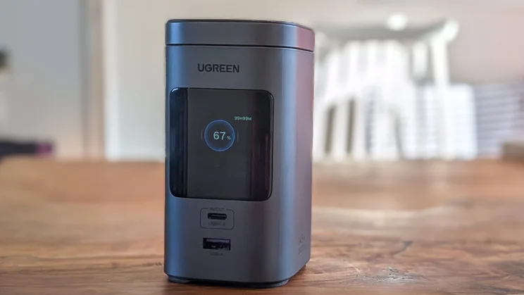 The Ugreen PB771 shown from the front on a wood table with the screen on