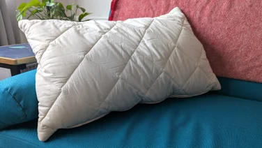 The Woolroom Deluxe Washable Wool Pillow on a blue sofa