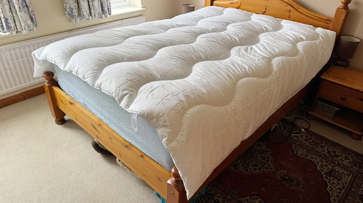 The Dreams Dream Team Washable Wool Duvet on a bed in a bedroom