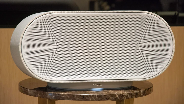 The Denon Home 600 wireless speaker on a stool-like table