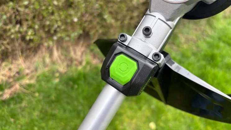 A closeup of the Ego ST1511E-T grass trimmer's line retract button