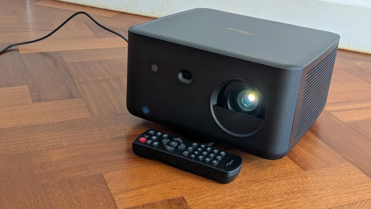 Front left view of the Optoma Photon Life PK32 projector on a wooden floor