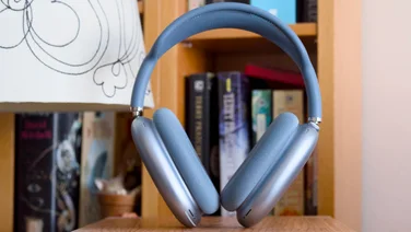 Apple AirPods Max 2 in blue in front of a bookshelf
