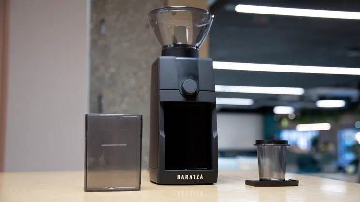 The Baratza Encore ESP Pro coffee grinder on a kitchen surface, with grounds collection drawer and single dose cup either side