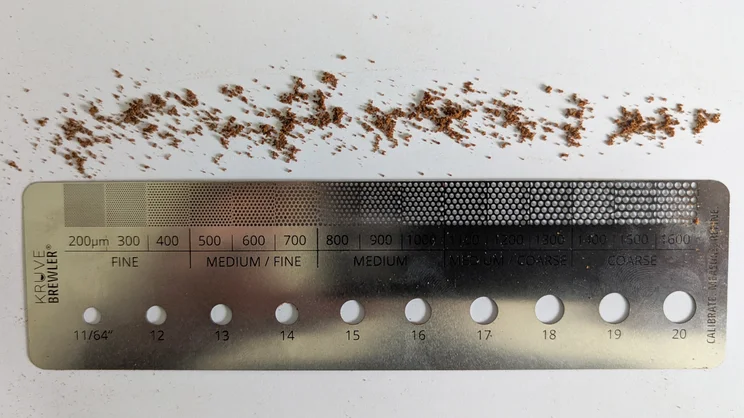 Coffee grounds spread along the edge of the Kruve Brewler: a specialised ruler designed to measure ground coffee