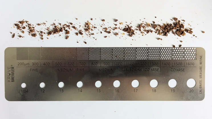 Coffee grounds spread along the edge of the Kruve Brewler: a specialised ruler designed to measure ground coffee