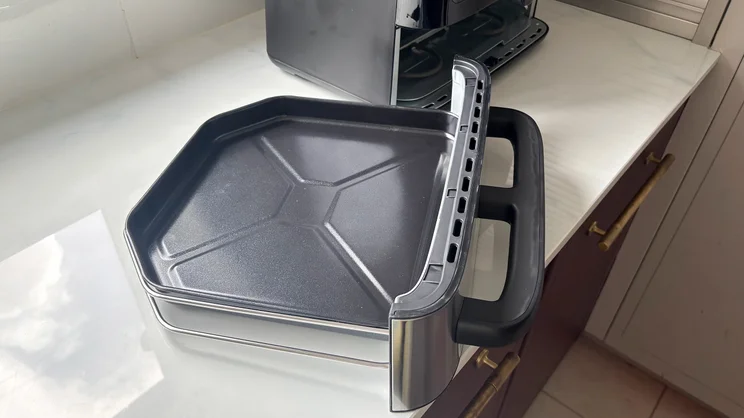 The bottom flat compartment of the Cuisinart Tri Zone 13.6l Air Fryer & Oven, on a kitchen worktop