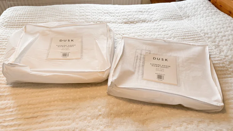 The Dusk Luxury 80% Goose Down duvets' carry bags, on a mattress