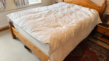 The Dusk Luxury 80% Goose Down duvet on a mattress in a bedroom