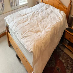 The Dusk Luxury 80% Goose Down duvet on a mattress in a bedroom