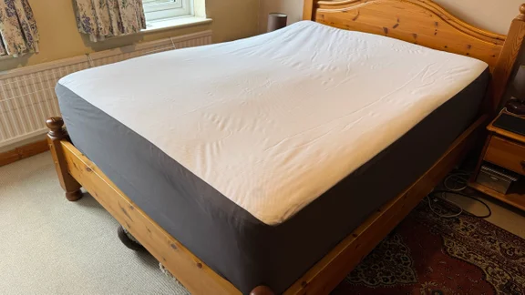 The Emma Mattress Protector on a wooden bed frame in a bedroom