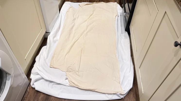 The Emma Mattress Protector sandwiched between two sheets, prepared for stain tests