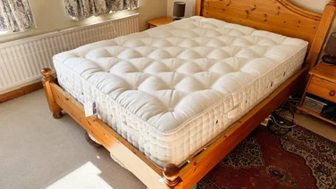 The Hypnos Inspired By Nature 05 mattress on a wooden bed frame in a bedroom