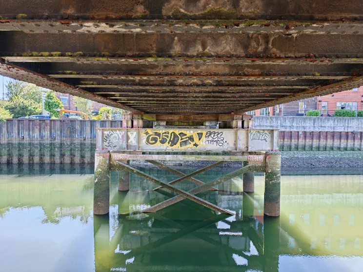 Shot from beneath a metal bridge across a river