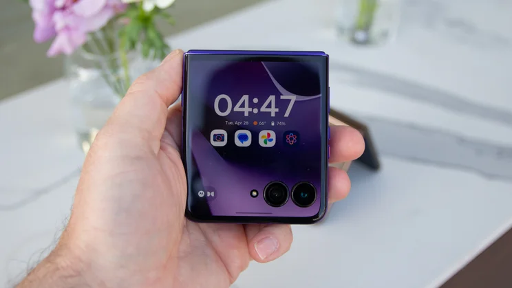 Razr 70 Ultra folded in hand, displaying the clock