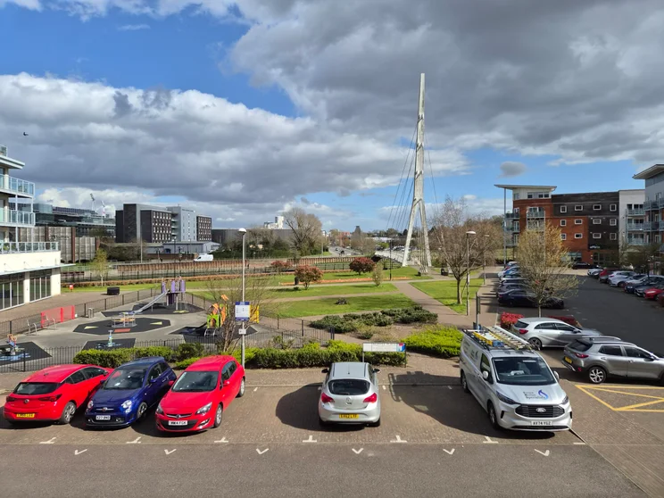A car park and play park with buildings all around