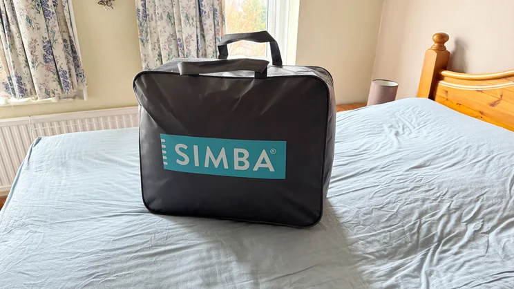 The Simba 3-in-1 duvet in its carry case, on a mattress