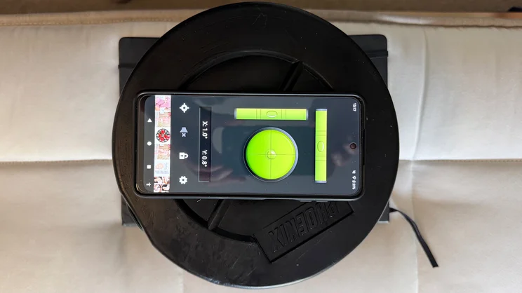 An birds-eye-view of a series of weights and smartphone on the surface of the Simba Natural Hybrid Escape mattress, being used to measure tilt