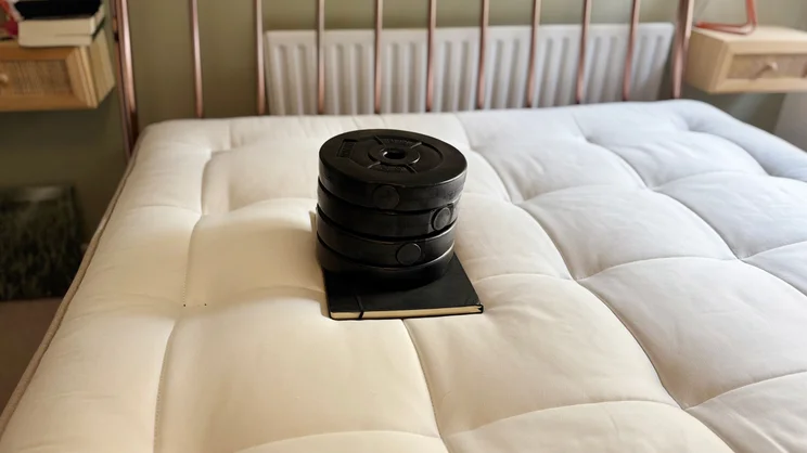 A series of weights sitting on the surface of the Simba Natural Hybrid Escape mattress, used to measure sinkage