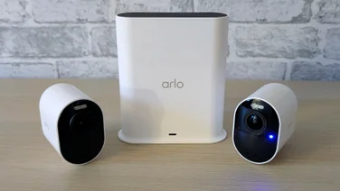 Two Arlo Ultra 3 security cameras, pictured with their smart hub