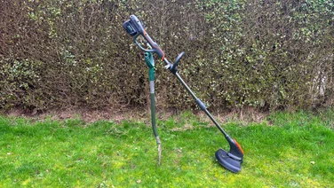 Flymo 18V UltraTrim 300 - wide shot of trimmer propped up on grass