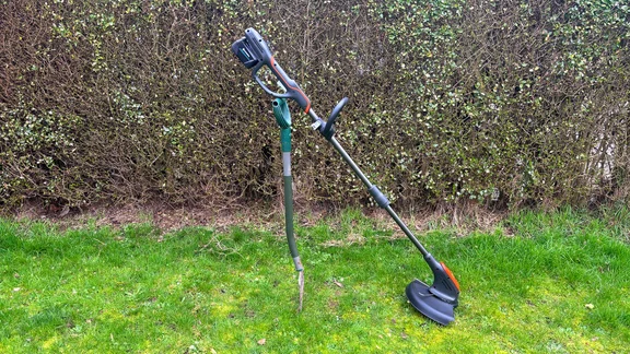 Flymo 18V UltraTrim 300 - wide shot of trimmer propped up on grass