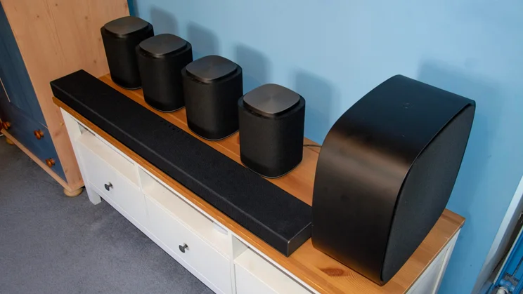 Side view of the LG Sound Suite H7 soundbar, four M7 speakers and the W7 subwoofer