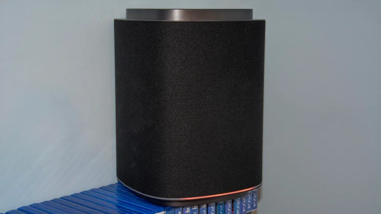 An LG Sound Suite M7 speaker on top of a selection of video game boxes