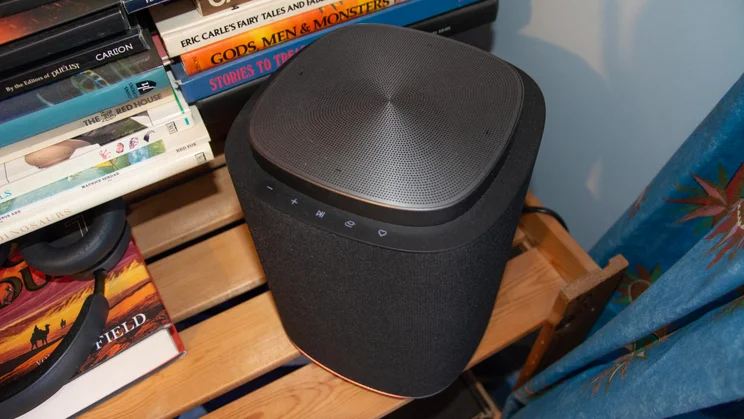Angled view of an LG Sound Suite M7 speaker next to a bookshelf