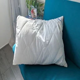 The Cuddledown ZeroMite Hygienic Washable Pillow on a blue sofa