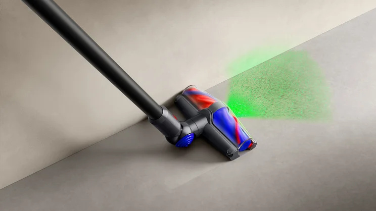 A concept image of the Dyson V10 Konical cleaning alongside a wall, its green headlight illuminating dust