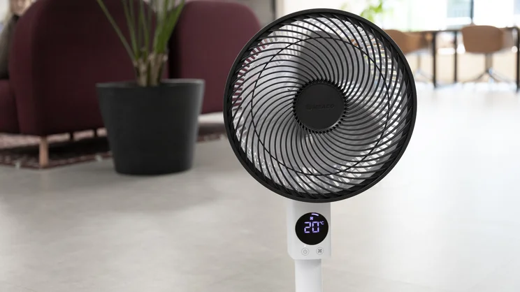 The Meaco Sefte Pro 10in Pedestal Fan at its lowest height, on the floor of an office. The fan's base is out of frame