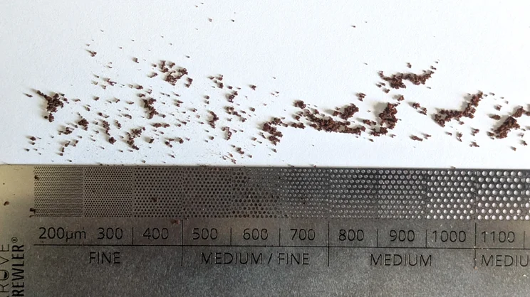 A bird's eye view of ground coffee being measured against the Kruve Brewler