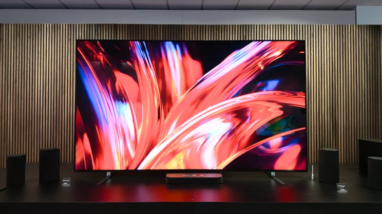 The 115in Sony Bravia 9 II shown on a stand surrounded with speakers