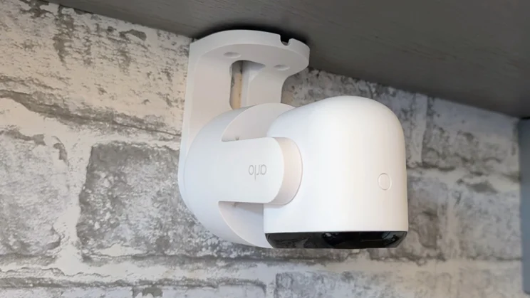 The Arlo Essential 3 pan tilt security camera mounted on the underside of a shelf, pointing down