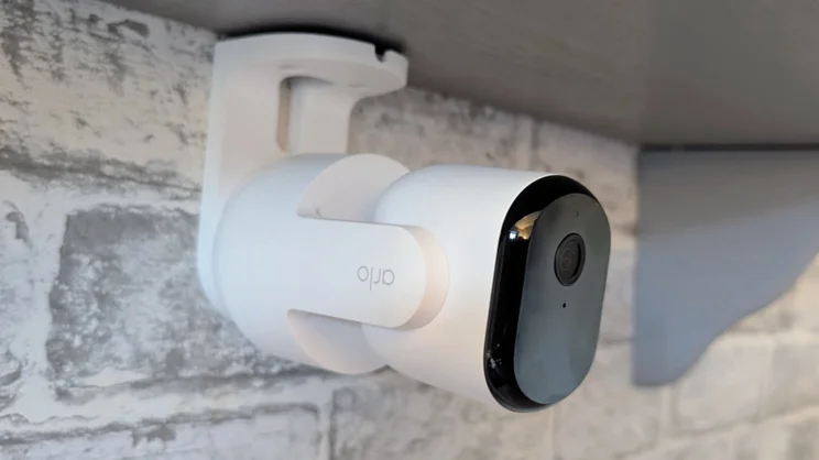 The Arlo Essential 3 pan tilt security camera mounted on the underside of a shelf