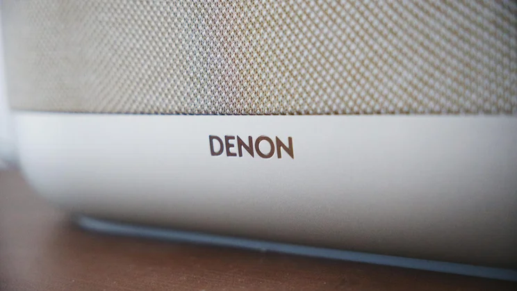 Close-up of the Denon logo on the front of the Denon Home 400 wireless speaker