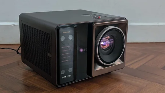 Front view of the Hisense XR10 projector on a wooden floor pointing to the right