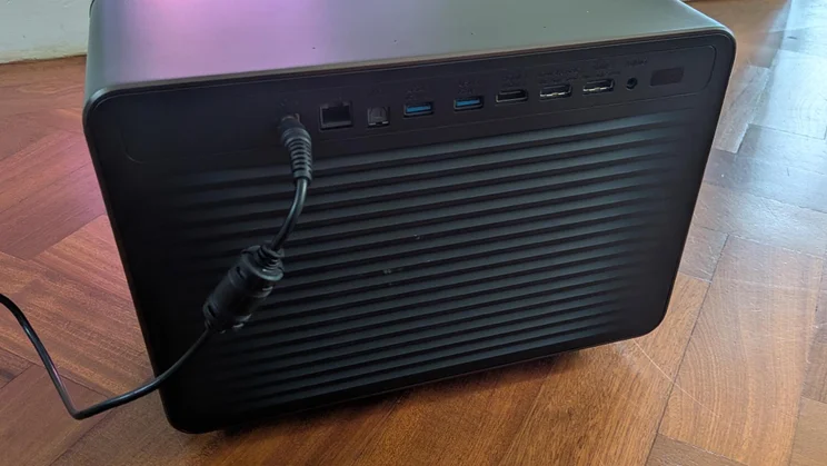 Rear view of the Hisense XR10 laser projector on a wooden floor, showing its various connection ports