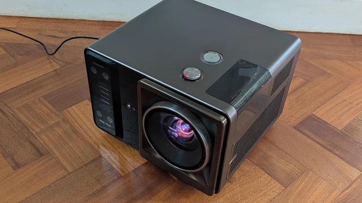 Top-down view of the Hisense XR10 projector on a wooden floor facing to the left