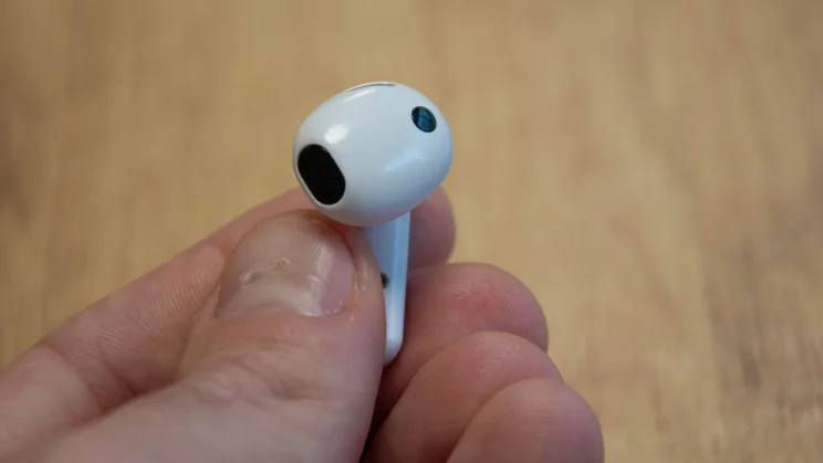 A single Samsung Galaxy Buds4 earbud being held in between fingers