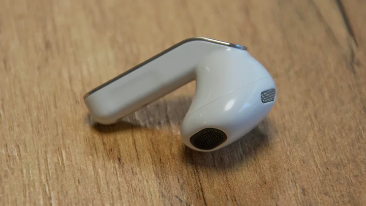 A single Samsung Galaxy Buds4 earbud on a wooden table showing its stem and sonic enclosure