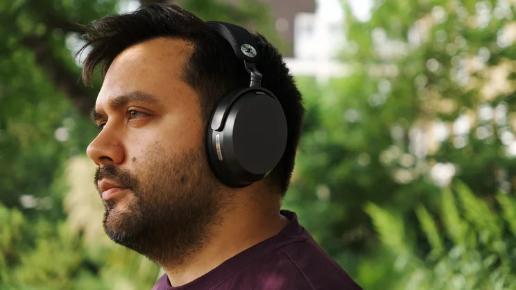 The Sennheiser Momentum 5 Wireless over-ear headphones being worn and viewed from an angle